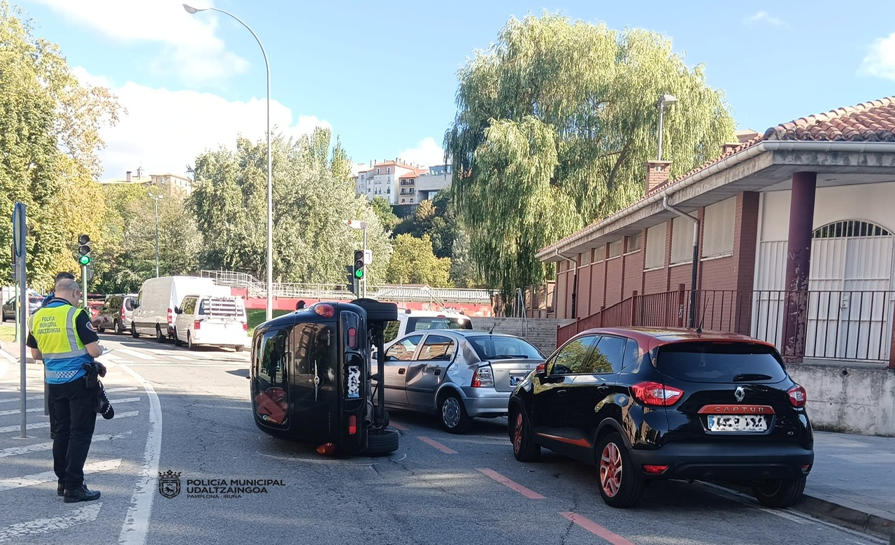 Ilesos tras estrellar su turismo contra varios coches estacionados junto a Corralillos y quedar volcado en la carretera