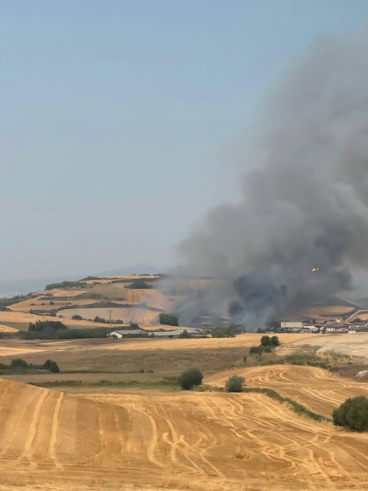 Bomberos trabajan en la extinción de un incendio de vegetación declarado en un campo cosechado de Salinas de Pamplona